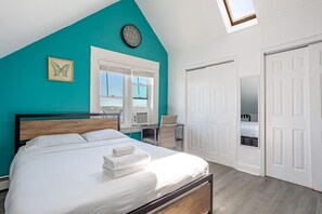 Un dormitorio con cama, ventana, silla, escritorio y armario.