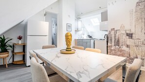 Ein moderner Essbereich mit einem Marmortisch, Stühlen, einer Goldtrophäe und einem Stadtbild.