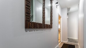 Un couloir orné d’un panneau de bois décoratif et d’un miroir mural.