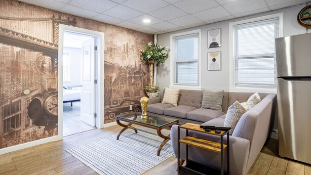 Un salon moderne avec un canapé, une table basse et un réfrigérateur.