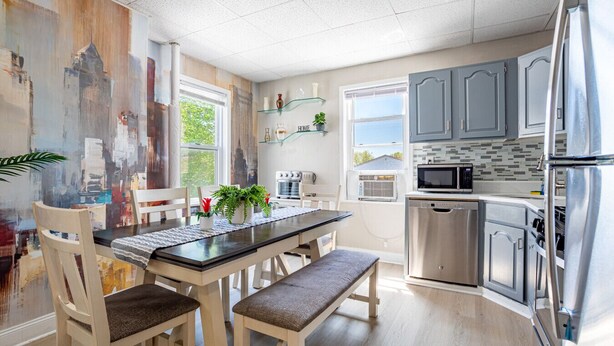 Une cuisine moderne avec une table à manger, des chaises et un réfrigérateur.