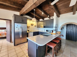 Enjoy cooking in this kitchen with a large island, bar stools, a refrigerator, and oven.