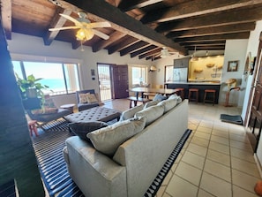 Relax in this spacious living area with a high ceiling, featuring a sofa and a small dining table.