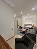 Een moderne hotelkamer met een bed, een bank, een stoel en een kleine tafel.