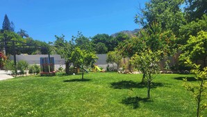 A well-maintained grassy yard with trees and a playground. - Anasa Residence (Chania)