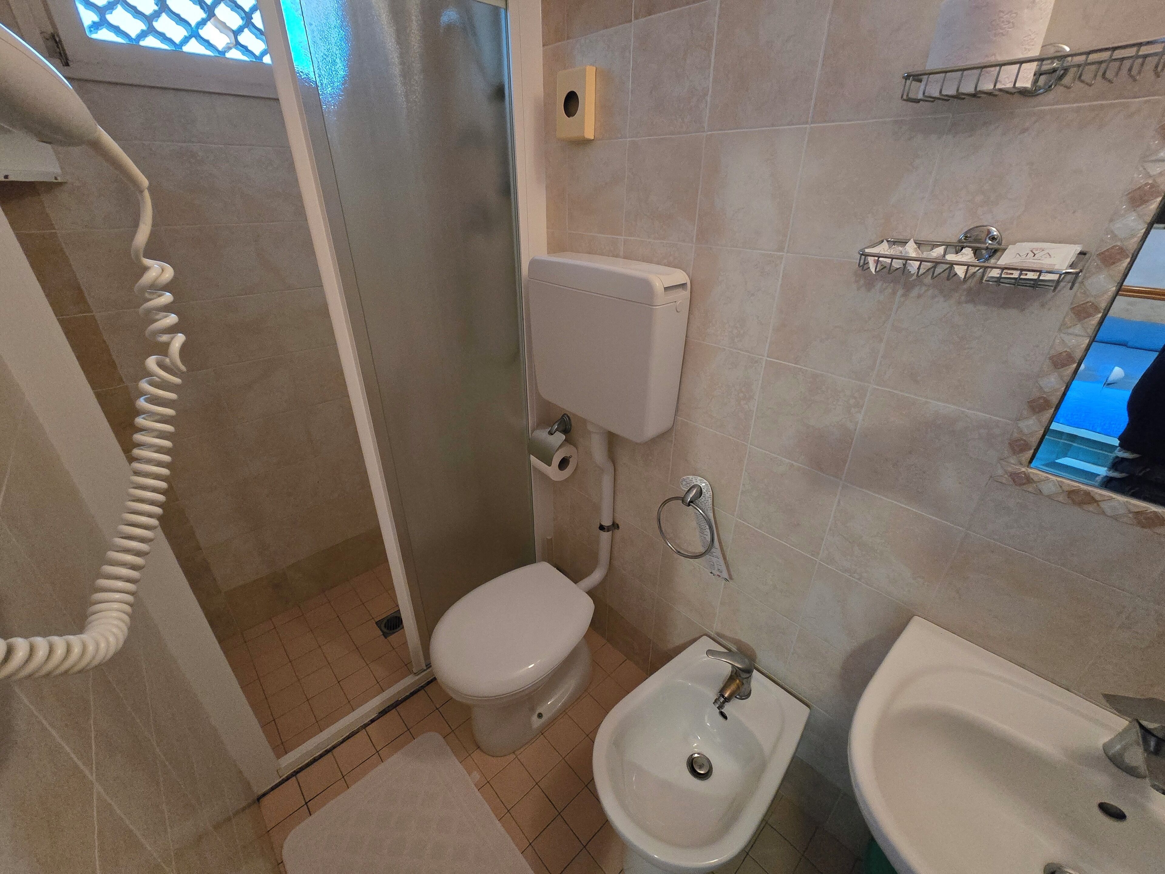 A bathroom with a toilet, bidet, and sink.