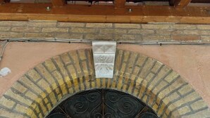 A wooden ceiling with exposed beams, a brick archway, and a decorative metal door with the inscription "EDO". - Entire lodging in peasant house at the foot of Majella - Agricasa Caprafico (Abruzzo)