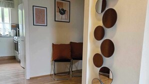 A modern living room with a brown sofa, a coffee table, and a wall-mounted mirror arrangement.