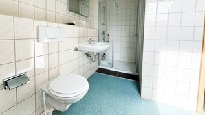 A bathroom with a toilet, sink, and shower. - Room with queen size bed and bathroom, tv, Netflix, wifi (Rudolstadt)