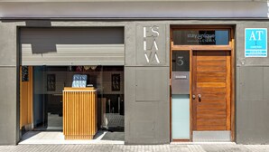 Fachada de edificio moderno con puerta de madera, buzón de metal y un letrero que dice