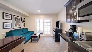 A modern kitchen with a flat-screen TV, a coffee maker, and a toaster.