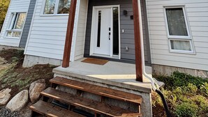 A two-story house with a front porch, a garage, and a driveway.