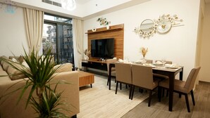 Ein modernes Wohnzimmer mit einer Couch, einem Esstisch und einem Fernseher.