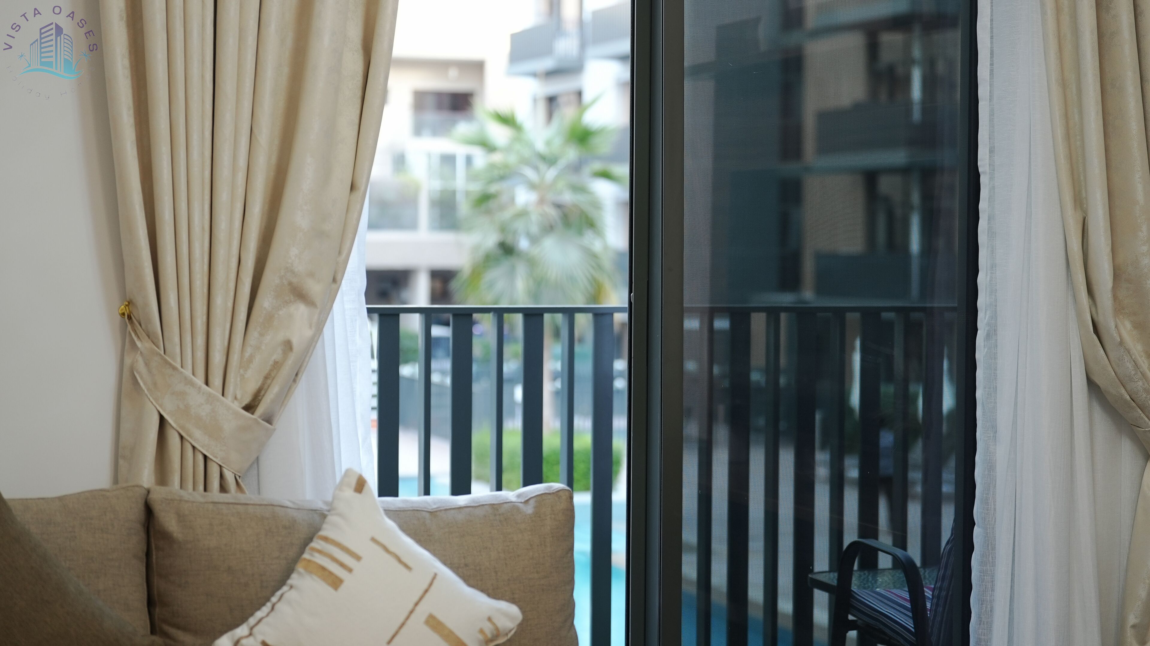 Ein Balkon mit Blick auf ein Gebäude und eine Palme.