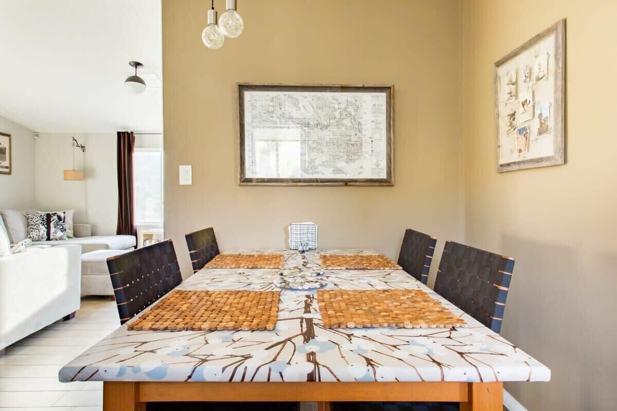 A dining area with a large table, chairs, and a map on the wall.