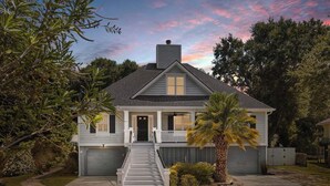 Une maison à deux étages avec un porche à l’avant, une cheminée et un garage.