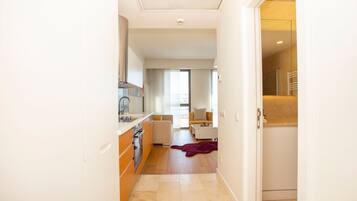 A modern kitchen with a built-in oven and a dining area with a sofa and a coffee table.