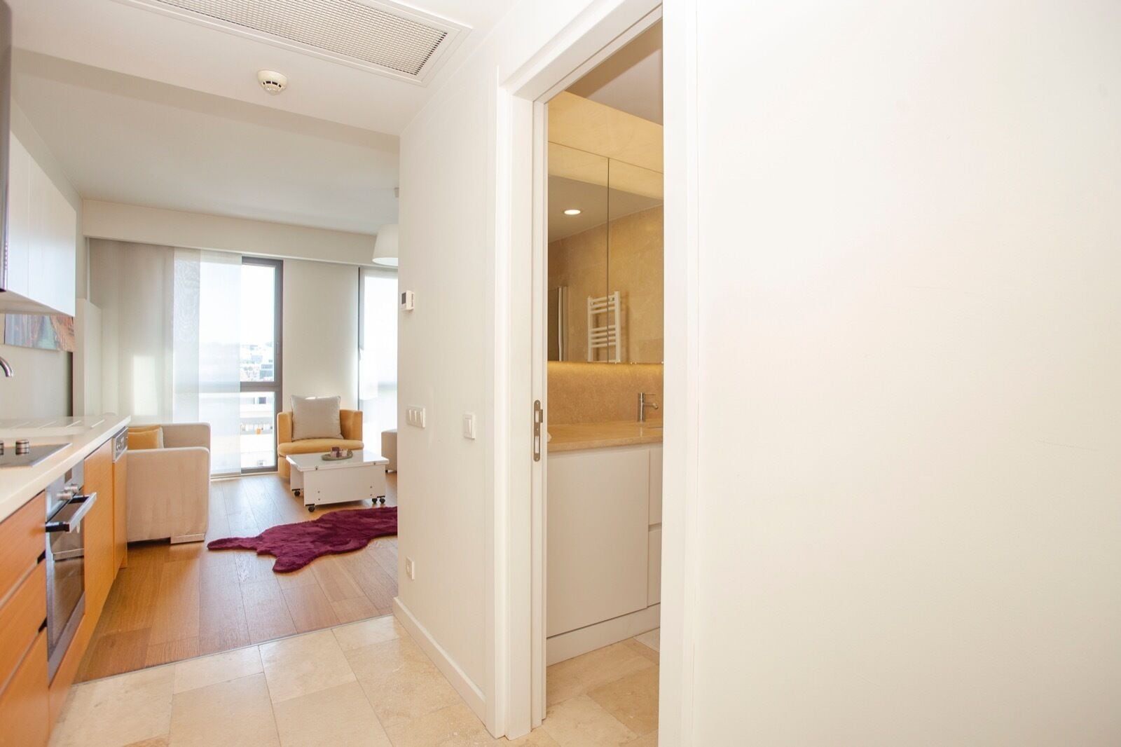 A modern apartment with a kitchen, living area, and a view of the city.