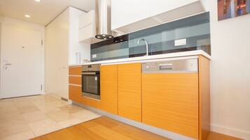 A modern kitchen with wooden cabinets, a stainless steel oven, a dishwasher, and a glass backsplash.