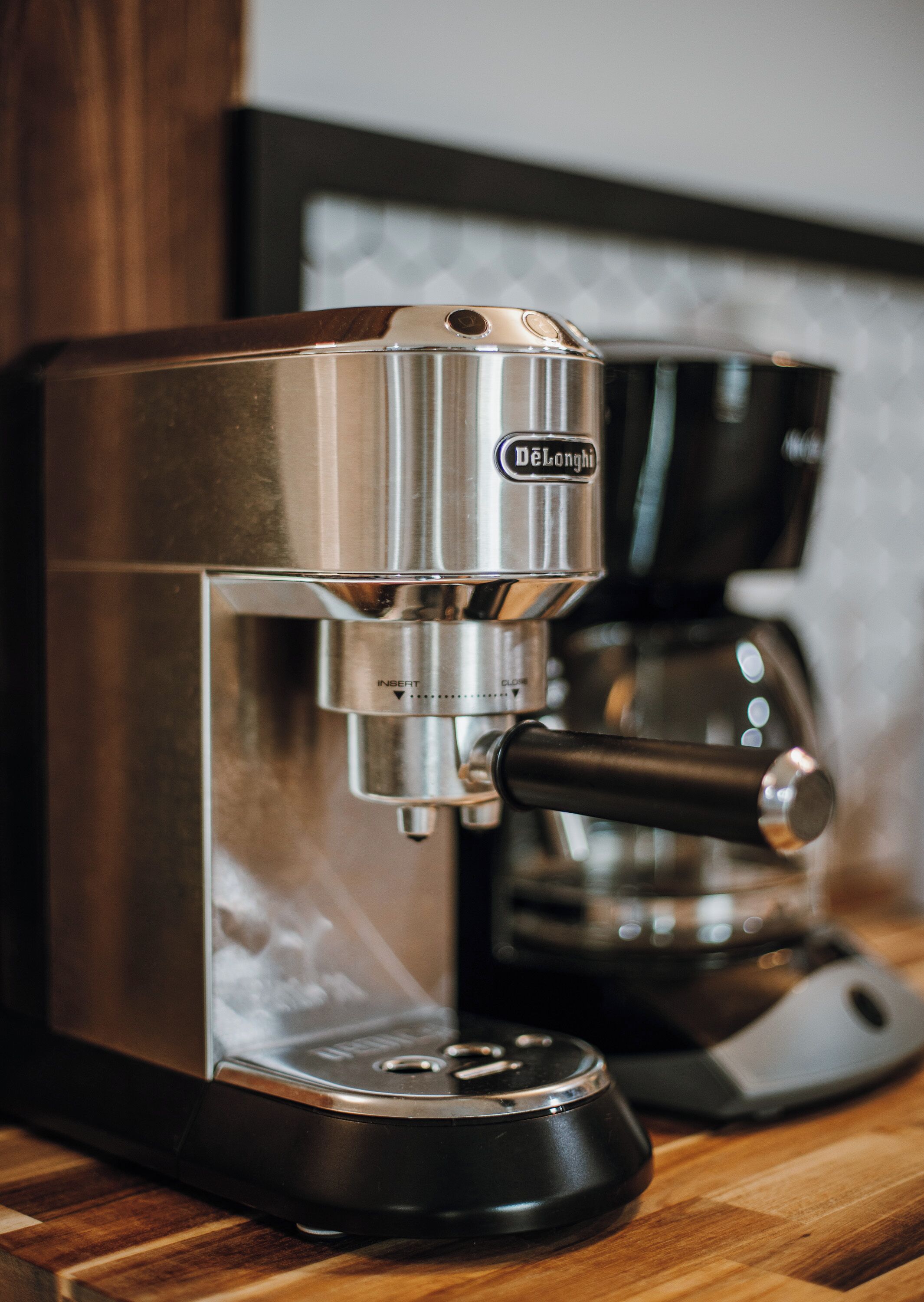Een De'Longhi espressomachine op een houten aanrecht.