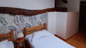 A small, cozy room with two wooden beds, a nightstand, and a white wardrobe. - House 8 sleeps 6 3 bedrooms (including mezzanine) (Ternant)