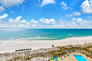 Un resort frente a la playa con piscina, acceso directo a la arena y una torre de salvavidas.