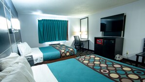 A hotel room with two beds, a desk, a TV, and a microwave.