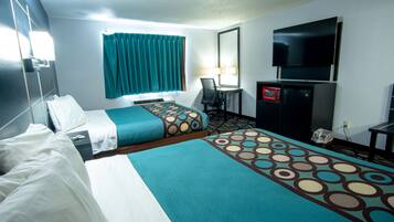 A hotel room with two beds, a desk, a TV, and a microwave.