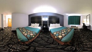 A hotel room with two beds, a desk, and a chair.