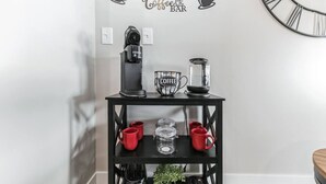 A black coffee station with a Keurig coffee maker, a coffee pot, and a coffee mug on a black shelf. - Walk to Bengals, Reds, Free Parking, King Bed, Gym (Cincinnati)