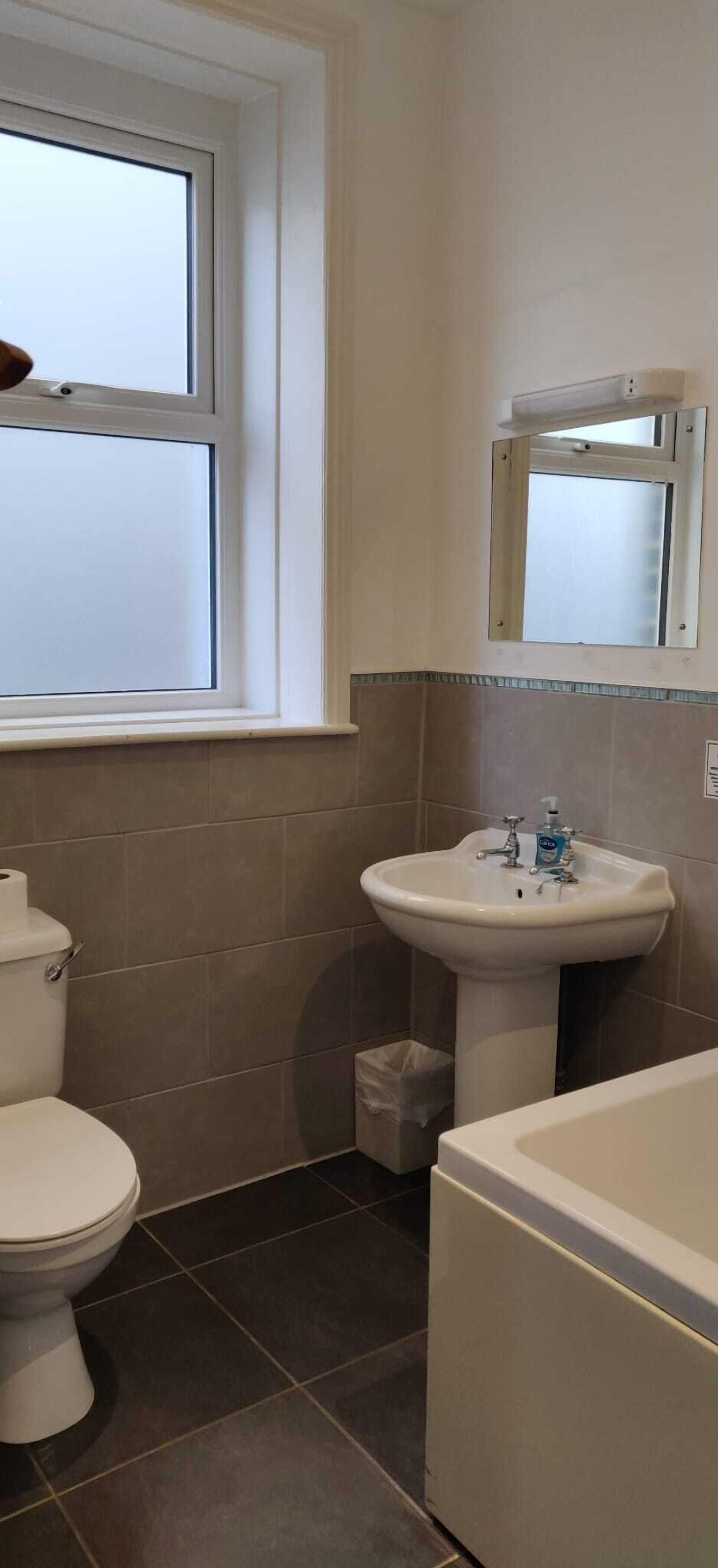 A bathroom with a toilet, sink, and bathtub.