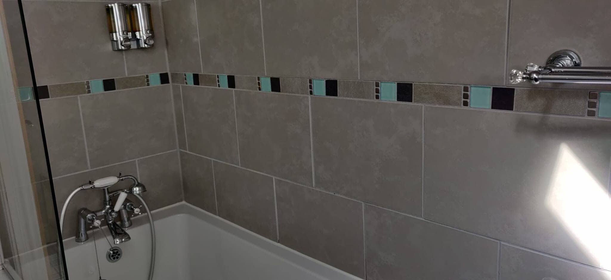 Un baño con bañera, ducha y perchero.
