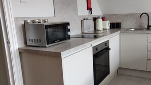A compact kitchen with a microwave, kettle, and sink. - Bodalwyn Guest House (Aberystwyth)