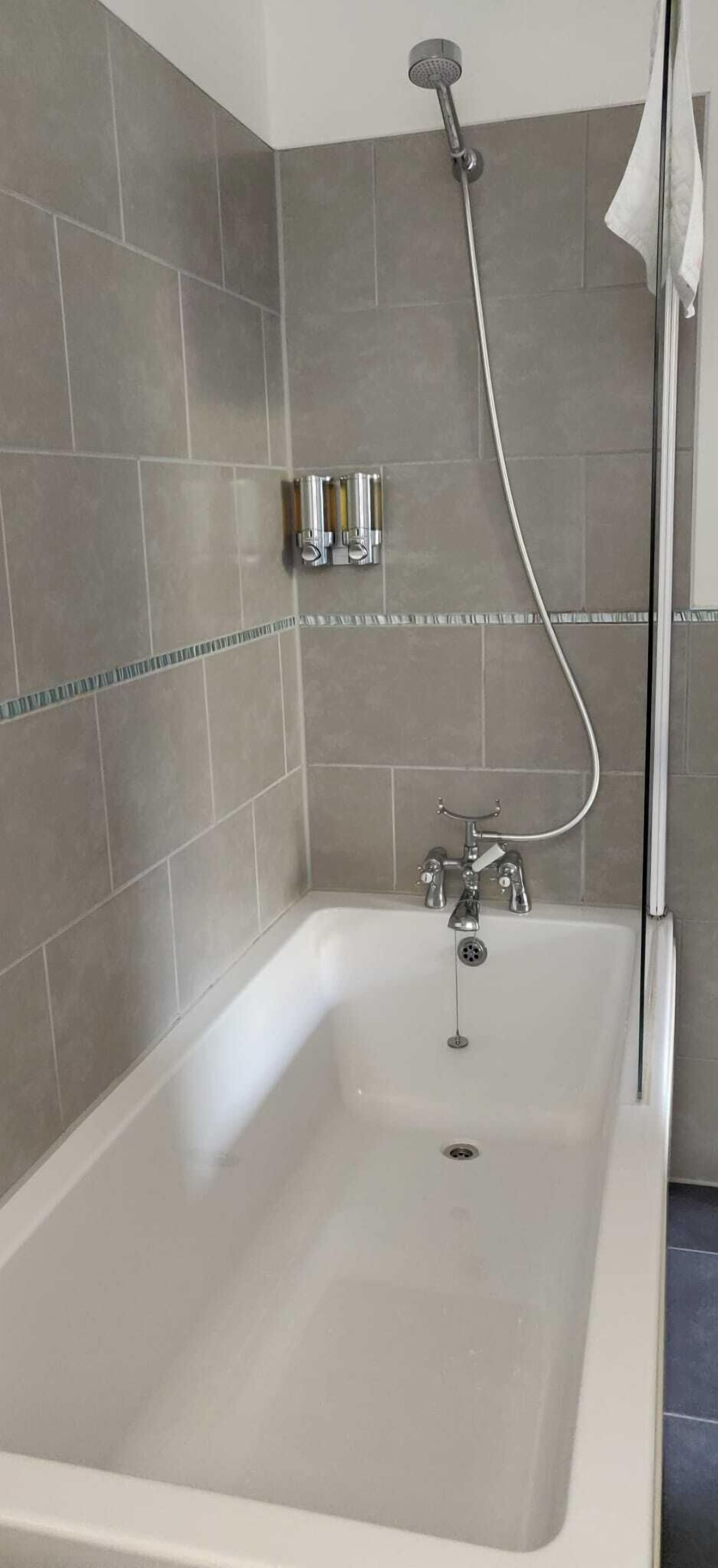 Un baño moderno con bañera, ducha y toallero.