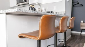 Una cocina con encimera de granito, electrodomésticos de acero inoxidable y un perchero.