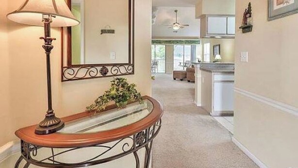 A hallway with a lamp, a mirror, and a small table with a plant. - Marvelous 2-bedroom house with AC in Myrtle Beach (Myrtle Beach)