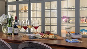 A bar area with wine bottles, glasses, and a cheese platter. - The Inn on Church Road (Hershey)