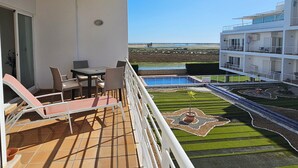 A balcony with a table and chairs, a small pool, and a view of the beach. - Seafront Complex with private pool, two bedroom apartment fully equipped (Fuseta)