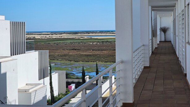 A corridor with a view of a beach and dunes. - Seafront Complex with private pool, two bedroom apartment fully equipped (Fuseta)