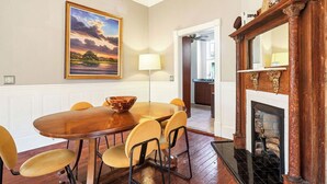 Un comedor con una mesa y sillas de madera, un cuadro en la pared y una chimenea.