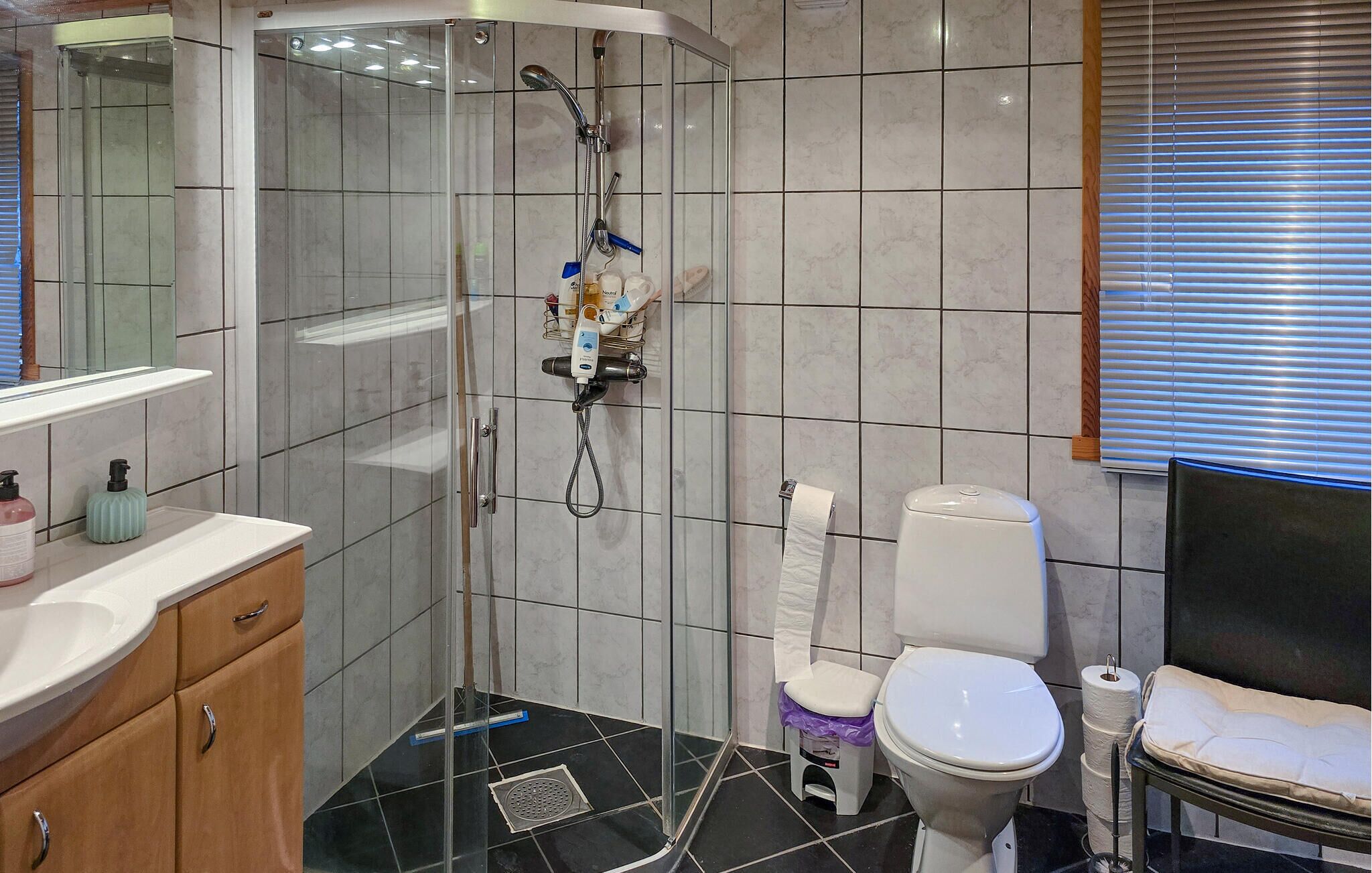 A modern bathroom with a glass-enclosed shower, a toilet, and a sink with a vanity.