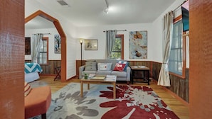 A cozy living room with a sofa, coffee table, and artwork on the walls.