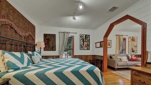 Ein Schlafzimmer mit einem großen Bett, einem Sofa und einem hölzernen Bogen.