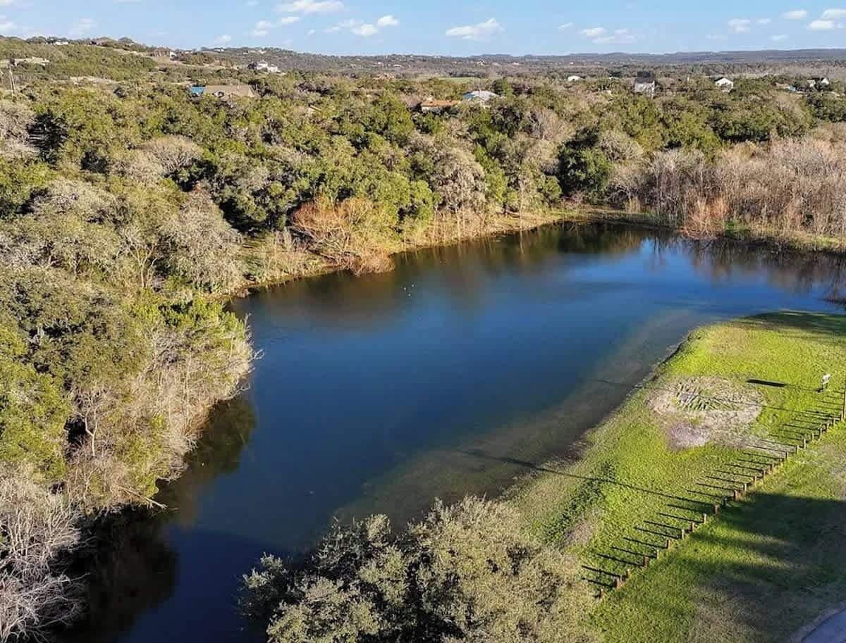 A river with a grassy bank and a small circular clearing.
