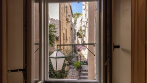 A view from a window of a narrow street with buildings, a street lamp, and a staircase. - Forkira Luxury Hvar (Hvar)