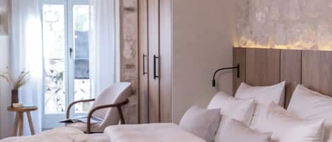 Quarto com cama, uma cadeira e vista para o exterior.