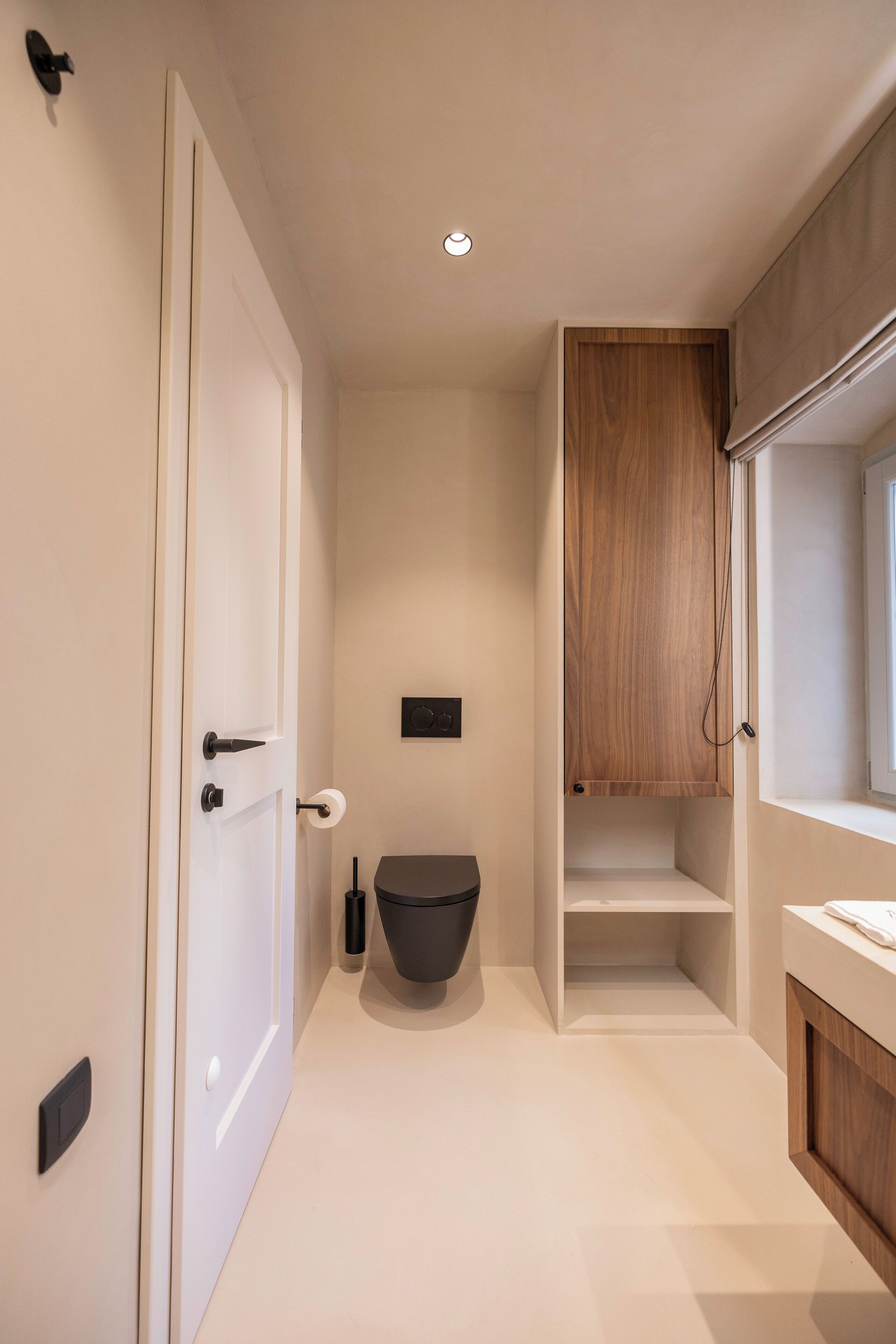 Ein modernes Badezimmer mit Toilette, Waschbecken und Stauraumschrank.