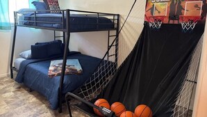 A bunk bed room with a basketball hoop and balls.