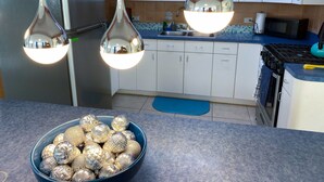 A kitchen with white cabinets, a stainless steel refrigerator, a blue countertop, and a bowl of decorative balls. - Charming 3-bedroom house in delightful Isabela with Wi-Fi, AC

 (Isabela)