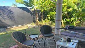 An outdoor seating area with wicker chairs, a small round table, and a white coffee table. - Charming 3-bedroom house in delightful Isabela with Wi-Fi, AC

 (Isabela)